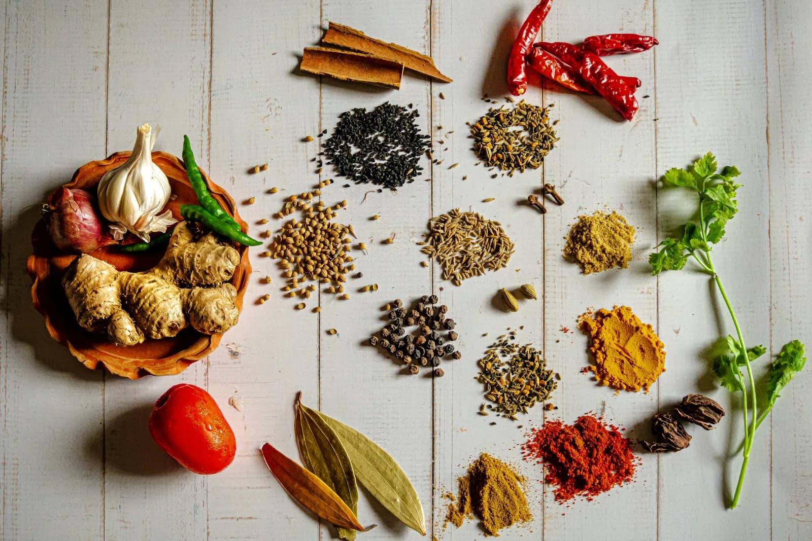 Artisanal spices and vanilla pods arranged on natural stone